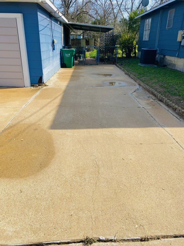 The same driveway after pressure washing, still wet