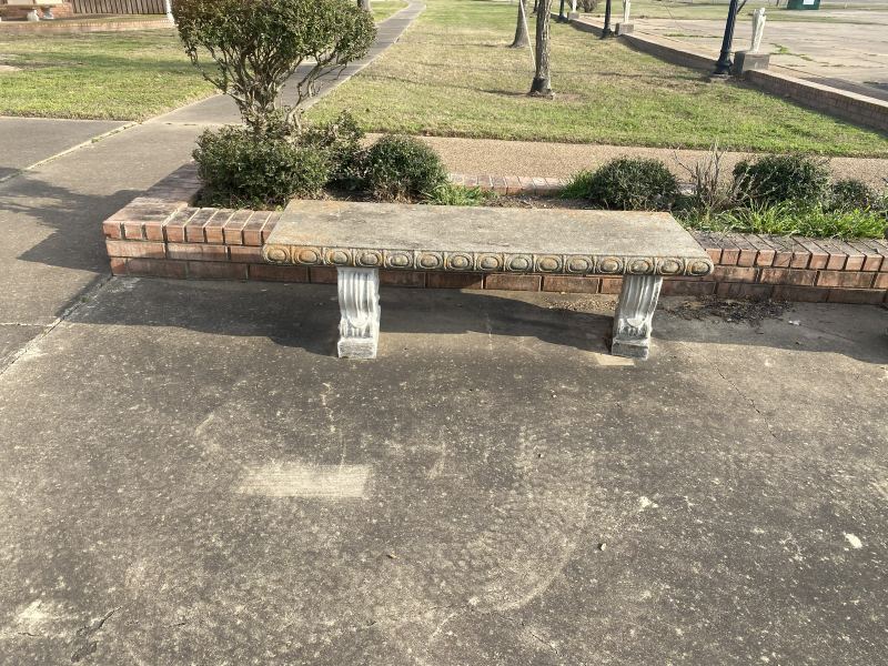 Decorative concrete bench at St. Ann Catholic Church with dark weathering before cleaning
